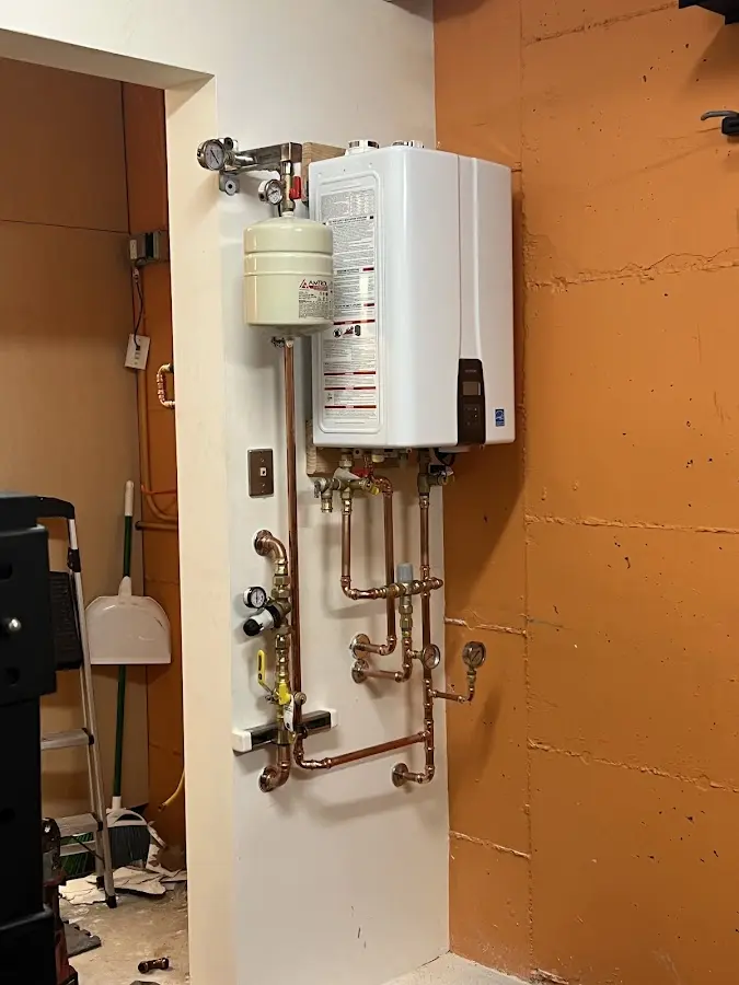 Plumbing technician inspecting water heater connections in Terrytown